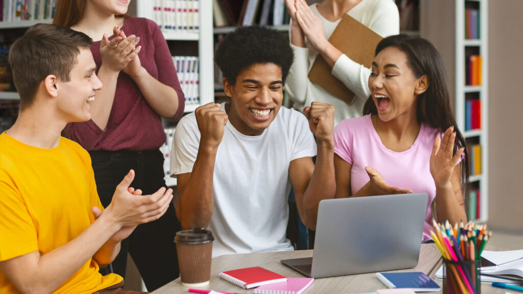 students happy at a laptop